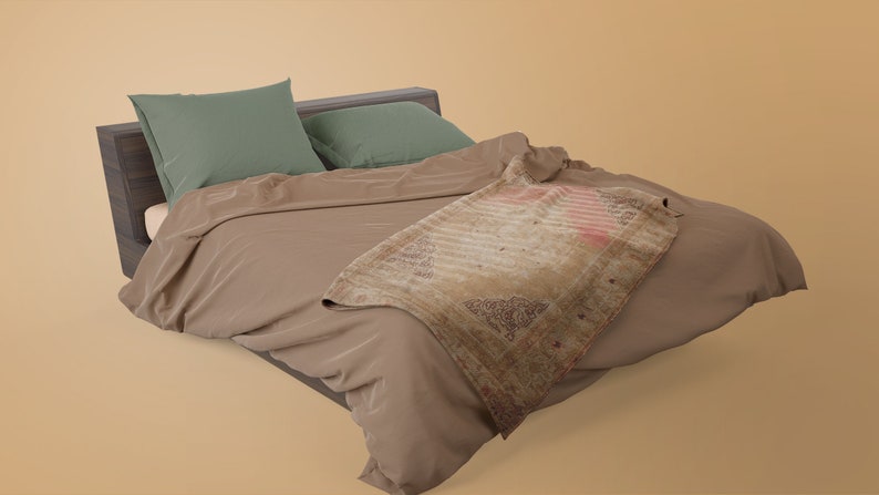 K&ouml;nnte beinhalten: Ein braunes Bett mit einem Holz-Kopfteil und zwei gr&uuml;nen Kissen. Eine braune Decke ist &uuml;ber das Bett gelegt, mit einem gemusterten &Uuml;berwurf dar&uuml;ber.