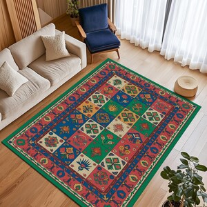 Puede incluir: Una alfombra colorida con un diseño geométrico. La alfombra presenta un borde verde y un diseño central de cuadrados en rojo, azul, verde y amarillo, cada uno con motivos florales y geométricos. Está colocada sobre un suelo de madera.