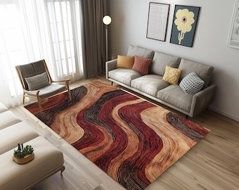 May include: A modern abstract area rug with a wavy, striped pattern in shades of brown, red, and beige. The rug is laid out on a hardwood floor in a living room setting with a sofa and armchair.