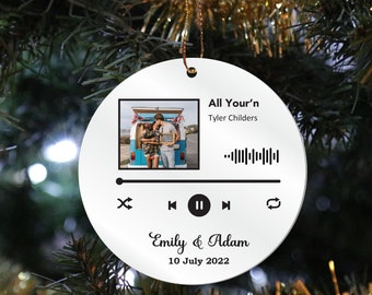 May include: White round Christmas ornament with a music player design. The ornament features a photo of a couple, the song title "All Your'n" by Tyler Childers, a bar code, play, pause, and skip buttons, and the text "Emily & Adam 10 July 2022".