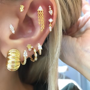 Trian piercing, piercing a catena pendente, piercing a perno, orecchino di cartilagine