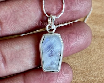 Op de afbeelding: Een zilveren ketting met een zilveren hanger in de vorm van een kist met een witte maansteen.