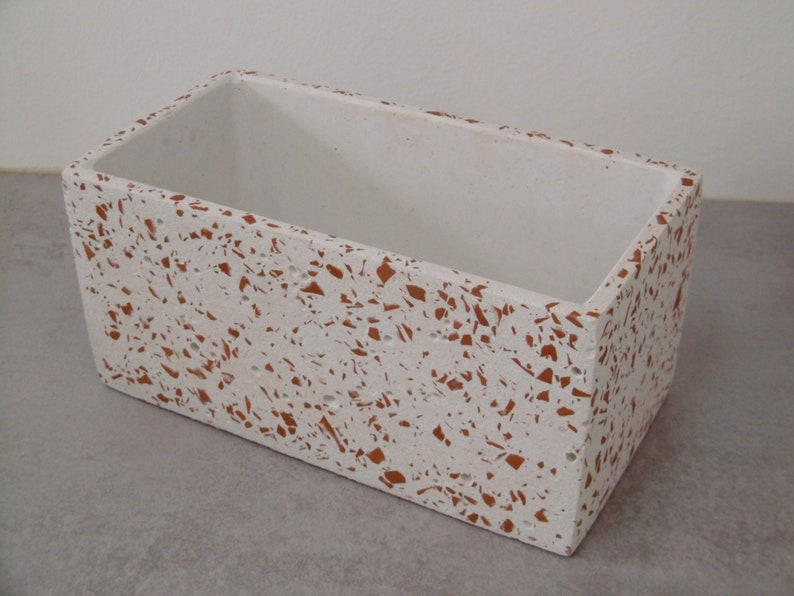 May include: White rectangular planter with a speckled terrazzo design in shades of white and brown.