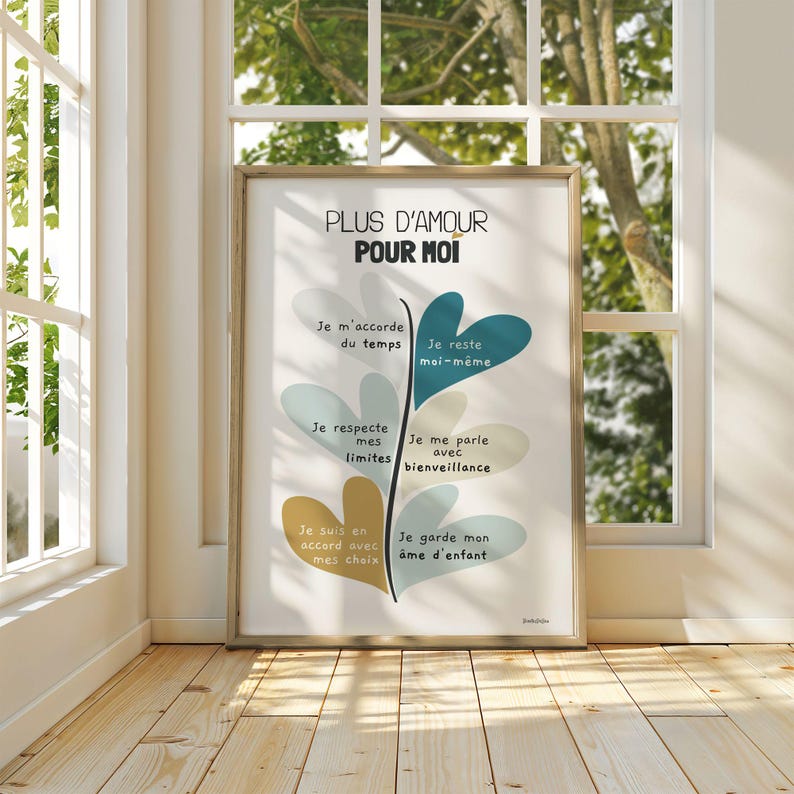 Affiche dans un grand cadre posé au sol, contre une fenêtre. Les rayons du soleil traversent la vitre, baignant l’illustration d’une lumière douce et chaleureuse qui en souligne les couleurs et le message motivant.