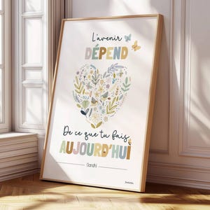 Peut inclure: Une affiche encadrée présentant une illustration florale en forme de cœur dans des tons doux. Le texte indique L'avenir DÉPEND De ce que tu fais AUJOURD'HUI et Gandhi. Le motif inclut des petits papillons et des éléments botaniques sur fond blanc.