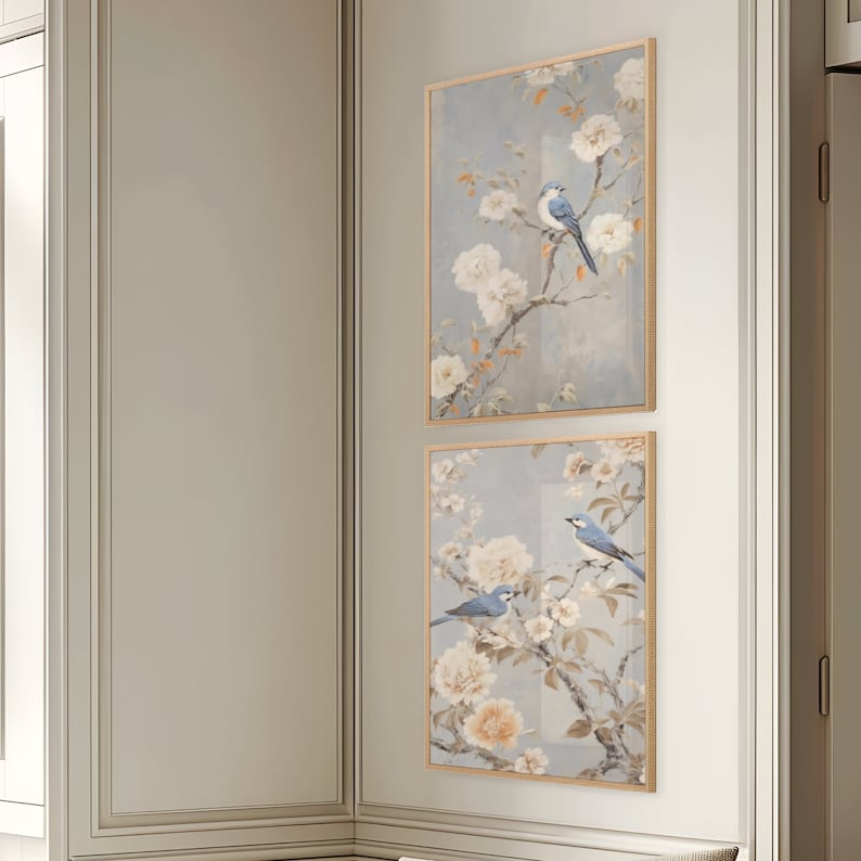 Puede incluir: Dos impresiones enmarcadas con un dise&ntilde;o floral azul y blanco y p&aacute;jaros azules. Las impresiones est&aacute;n colgadas en una pared blanca.