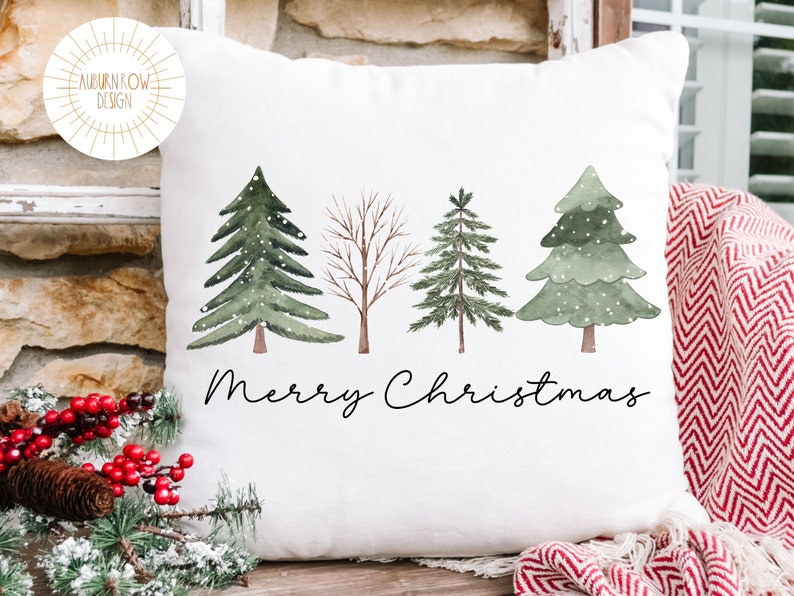 May include: White throw pillow with a watercolor design of four trees and the text "Merry Christmas".