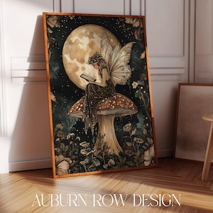 Pode incluir: Uma impressão de arte emoldurada com uma fada lendo em um cogumelo sob uma lua cheia. A fada tem asas delicadas e é cercada por flores e folhagens. A obra de arte tem um estilo vintage e caprichoso com o texto "AUBURN ROW DESIGN" na parte inferior.