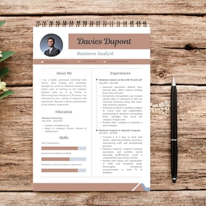 May include: A brown and beige resume template with a photo of a man in a suit at the top. The resume is for Davies Dupont, a Business Analyst. The resume includes sections for About Me, Education, Skills, and Experiences.