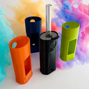 May include: Four different colored plastic cases for a vape device. The cases are orange, blue, green, and black. The black case has a clear glass tube attached to it.