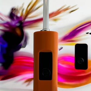 May include: A brown and black torch lighter with a silver metal nozzle. The lighter has a black rectangular display screen.