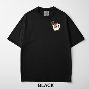 May include: Black t-shirt with a cartoon coffee cup graphic on the front. The graphic features a white coffee mug with a smiling face and coffee spilling out. The text "BLACK" is at the bottom.