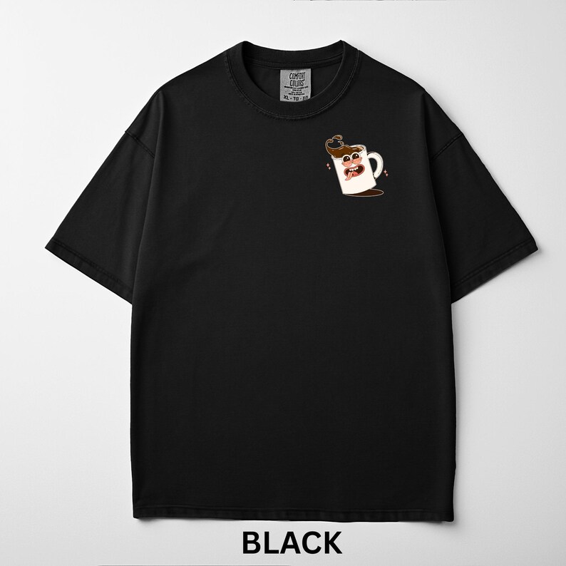 May include: Black t-shirt with a cartoon coffee cup graphic on the front. The graphic features a white coffee mug with a smiling face and coffee spilling out. The text "BLACK" is at the bottom.