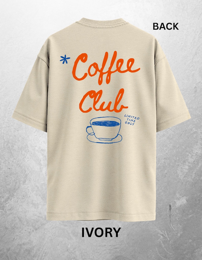 Może przedstawiać: Kremowa koszulka z napisem "Coffee Club" w pomarańczowym skrypcie, niebieską gwiazdką i niebieską grafiką filiżanki do kawy. Tekst "LIMITED TIME ONLY" znajduje się poniżej. Słowo "BACK" znajduje się na g&oacute;rze.
