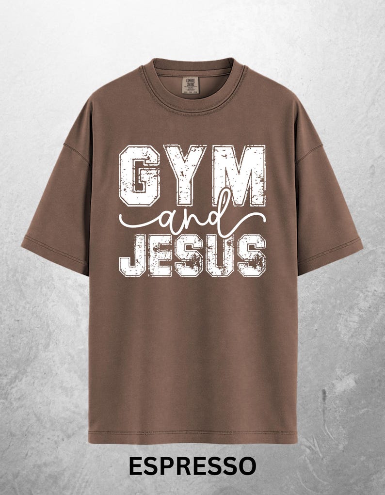 May include: Espresso-colored t-shirt with the text "GYM and JESUS" in distressed white lettering. The shirt has a crew neck and short sleeves. The word "ESPRESSO" is printed at the bottom of the shirt.