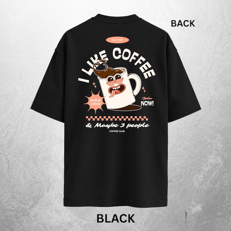 May include: Black t-shirt with a coffee-themed graphic. The design features a cartoon coffee mug with the text "I Like Coffee" and "& Maybe 3 people". Additional text includes "Brew Crew" and "Join Now!"