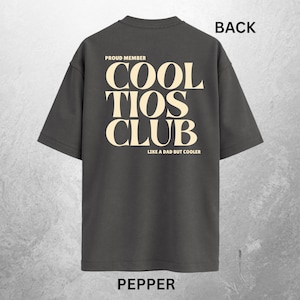 May include: Pepper-colored t-shirt with the text "PROUD MEMBER COOL TIOS CLUB LIKE A DAD BUT COOLER" in a cream-colored font. The word "BACK" is printed in black at the top. The word "PEPPER" is printed in black at the bottom.