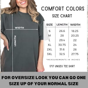 Może przedstawiać: Ciemnoszara koszulka unisex z tabelą rozmiar&oacute;w. Tabela pokazuje wymiary w calach dla rozmiar&oacute;w od S do 3XL. Tekst brzmi "COMFORT COLORS" i "1717 UNISEX TEE SHIRT". Obraz zawiera r&oacute;wnież tekst "FOR OVERSIZE LOOK YOU CAN GO ONE SIZE UP OF YOUR NORMAL SIZE."