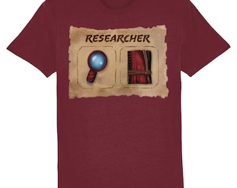 May include: A maroon t-shirt with a vintage-style illustration of a magnifying glass and a book with the word "RESEARCHER" above it.