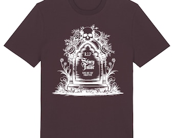 May include: Red-brown t-shirt featuring a white graphic of a tombstone with a skull, roses, and the text "R.I.P. Story Teller Gone But Not Forgotten." The shirt has a crew neck and short sleeves.
