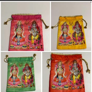 May include: Four colorful drawstring pouches. Each pouch features a printed image of Hindu deities Lakshmi and Ganesha. The pouches are in shades of pink, yellow, green, and orange, with gold trim and drawstrings. The word "Shubh" is printed on the pouches.