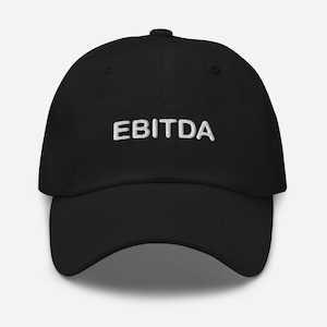May include: Black baseball cap with the white embroidered text "EBITDA" across the front. The cap has a curved brim and a fabric strap closure on the back.