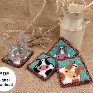 Peut inclure: Quatre dessous-de-verre en point d'aiguille turquoise et marron avec des motifs de vache. Les dessous-de-verre sont sur un fond en toile de jute avec une tasse en verre et un pot à lait vintage.
