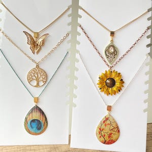 Gold pendant minimalist styles in different designs: sunflower, butterfly, tree, bird, peacock, snake chain