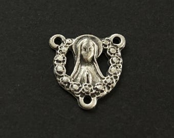 May include: Silver-toned metal charm featuring a depiction of the Virgin Mary with a floral wreath around her. The charm has three holes for attaching to a necklace or bracelet.