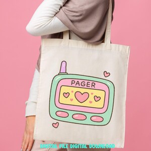 May include: Cream-colored tote bag featuring a cartoon pager design. The pager is outlined in mint green with a yellow screen displaying hearts and the word "PAGER". Pink hearts and a pink antenna complete the design. The words "DIGITAL FILE DIGITAL DOWNLOAD" are at the bottom.