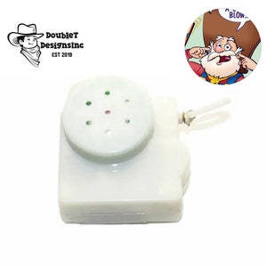 May include: A white plastic sound module with a round speaker and five small holes. The module has a loop attached to it. The module is a sound effect device.