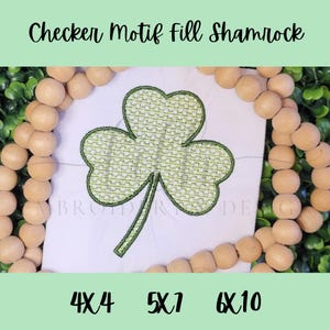 May include: A green shamrock design with a checker motif fill, displayed on a white background. The image includes the text "Checker Motif fill Shamrock" and size options: 4x4, 5x7, and 6x10. The design is surrounded by wooden beads.