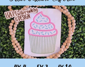 Op de afbeelding: Een satijnen outline-borduurontwerp van een cupcake met roze glazuur en blauwe sprinkles. Het ontwerp is verkrijgbaar in drie maten: 4x4, 5x7 en 6x10 inch.