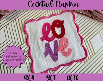 May include: White cocktail napkin with a scalloped edge, embroidered with the word "LOVE" in shades of pink and purple. The napkin is square-shaped and includes instructions and tips. The text "ITH Scallop Edge Cocktail Napkin" is at the top.