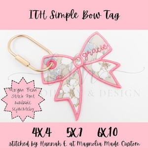 Könnte beinhalten: Ein besticktes Schleifen-Tag in Rosa und floralen Mustern, mit dem Namen "gracie" darauf gestickt. Es ist an einem goldfarbenen Schlüsselanhänger befestigt. Der Text "ITH Simple Bow Tag" steht oben. Der Text "Morgan Bean Stitch Font available separately" ist ebenfalls sichtbar.