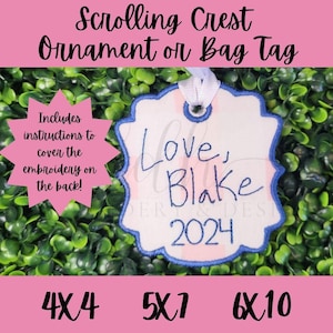 May include: A white, blue, and pink embroidered ornament or bag tag with the text "Love, Blake 2024". The ornament is on a green background.