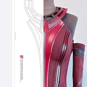 Puede incluir: Un disfraz rojo y negro con un diseño geométrico. El disfraz tiene un cuello alto y una tela texturizada. El disfraz se muestra en un maniquí.
