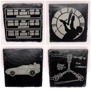 May include: Four black slate coasters with white text and images. The first coaster shows a digital clock with the date and time set to 5 November 1955, 06:15. The second coaster shows a clock face with a figure hanging from the hands. The third coaster shows a silver DeLorean time machine. The fourth coaster shows a diagram of a flux capacitor with the equation X+YX52 R13141=1614 and the text 65/x100x 4x4 time to FLUX COMPRESSION.