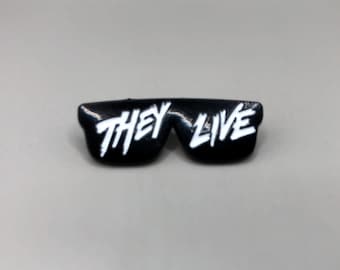 以下が含まれることがあります： レンズに「THEY LIVE」という白い文字が書かれた黒いサングラス。