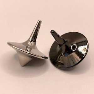May include: Two metal spinning tops, one silver and one black.