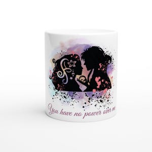 May include: White ceramic mug with a black silhouette of two people against a colourful watercolour background. The mug features the text "You have no power over me".