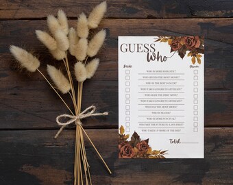 May include: A printable "Guess Who" game card with a fall theme. The card has a floral design with red, orange, and brown flowers. The text on the card reads "Guess Who" and includes questions about the bride and groom.