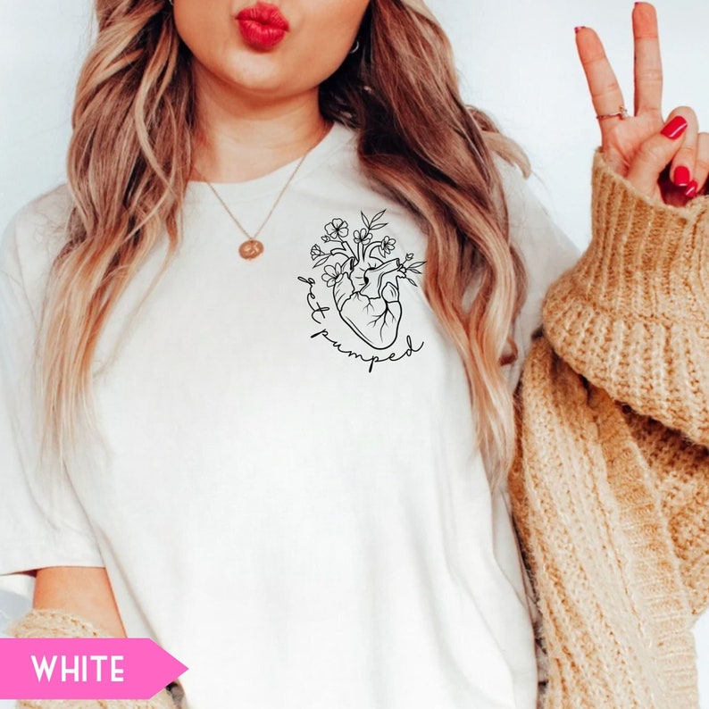 K&ouml;nnte beinhalten: Wei&szlig;es T-Shirt mit einer schwarzen Linienzeichnung eines Herzens, aus dem Blumen wachsen. Der Text "get pumped" ist um das Herz herum geschrieben.