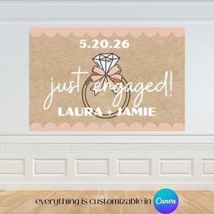 May include: A large banner with a diamond ring graphic and the words "just engaged!" in white script. The banner includes the date 5.20.26 and the names LAURA + JAMIE. The background is a textured tan color with a scalloped border.