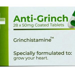May include: A white box with green accents and a green and white pill. The box reads "Anti-Grinch 28 x 50mg Coated Tablets Grinchistamine&trade; Specially formulated to: grow your heart."