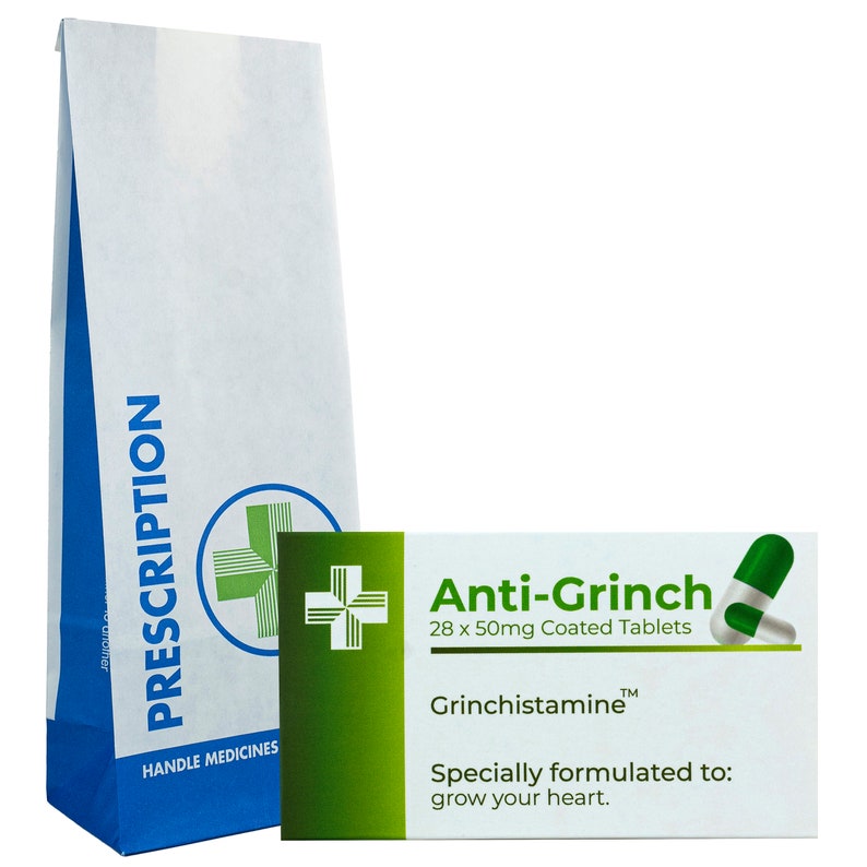 May include: A white paper bag with a blue stripe and the word "PRESCRIPTION" printed on it. The bag has a green cross logo and the text "HANDLE MEDICINES". Next to the bag is a white box with green accents. The box has the text "Anti-Grinch 28 x 50mg Coated Tablets" and "Grinchistamine&trade;" printed on it. The box also has the text "Specially formulated to: grow your heart."