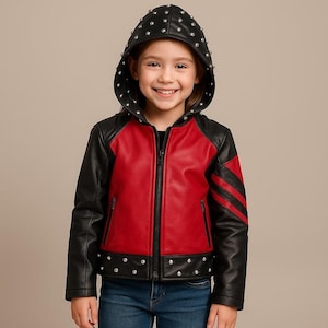 Può includere: Giacca con cappuccio rossa e nera con borchie argentate. La giacca ha un pannello frontale rosso, maniche nere e un cappuccio nero. Il cappuccio e l'orlo inferiore sono adornati con borchie argentate. La giacca è chiusa con la cerniera.