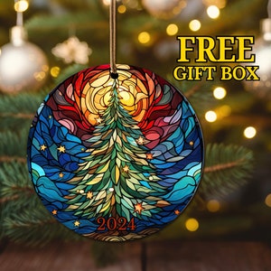 Puede incluir: Un adorno navide&ntilde;o redondo con un dise&ntilde;o de vitral de un &aacute;rbol de Navidad con un sol y estrellas. El adorno es verde, azul, amarillo, naranja y rojo. El a&ntilde;o 2024 est&aacute; impreso en el adorno.