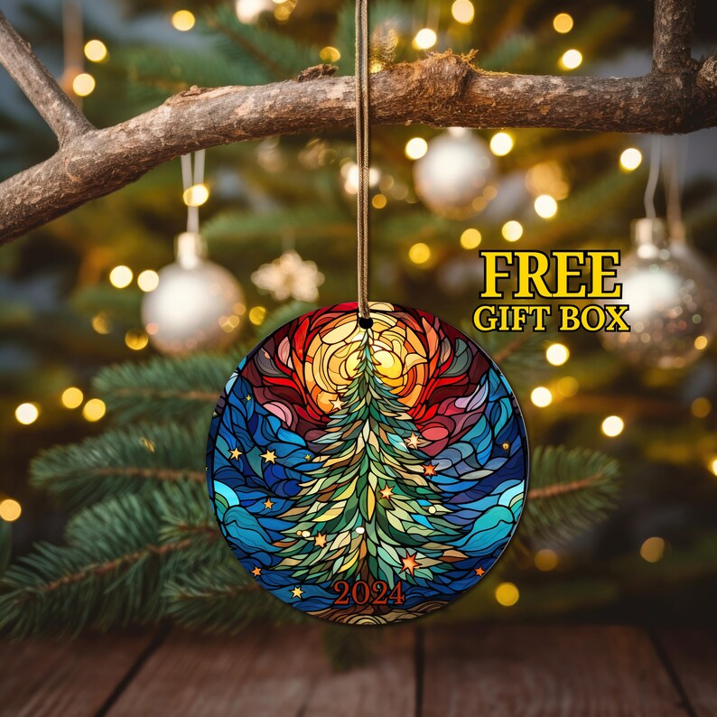Puede incluir: Un adorno navide&ntilde;o redondo con un dise&ntilde;o de vitral de un &aacute;rbol de Navidad con un sol y estrellas. El adorno es verde, azul, amarillo, naranja y rojo. El a&ntilde;o 2024 est&aacute; impreso en el adorno.