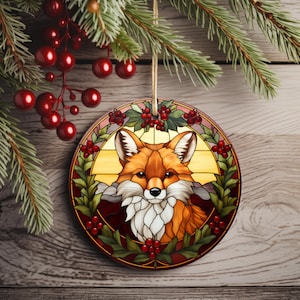 May include: A round glass ornament with a stained glass design of a fox's face surrounded by holly and red berries.